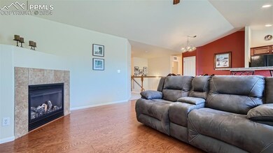 Living room featuring lofted ceiling, a tiled fire