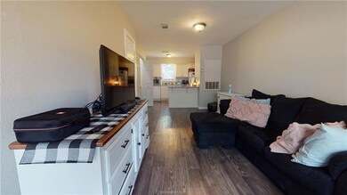 Living area with dark wood-style flooring and visi