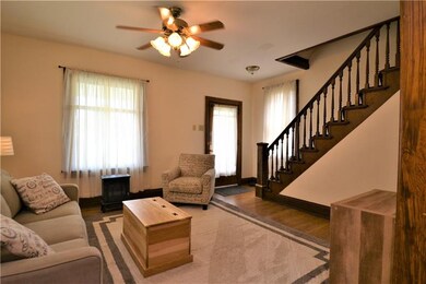LIVING ROOM WITH TALL CEILING AND HARDWOOD FLOORS
