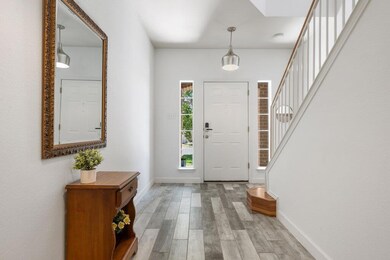 Foyer with light wood-style floors and stairway