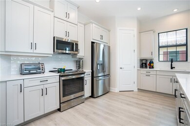 Kitchen with backsplash, appliances with stainless steel finishes, light wood-style flooring, white cabinets, and recessed lighting