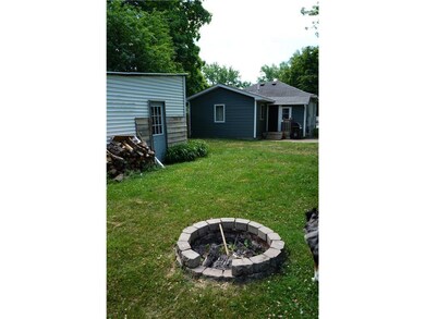 Back view with fire place and shed