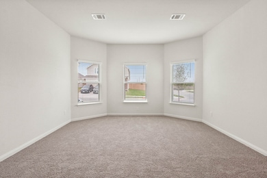 Empty room featuring light colored carpet and healthy amount of natural light