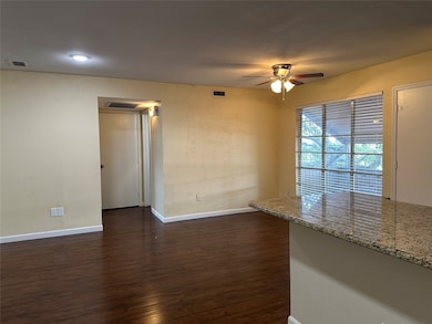 Empty room with dark wood-style flooring and a ceiling fan