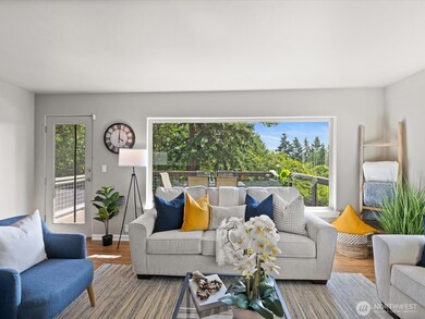 View from main floor living room and doorway to trex deck, overlooking lush backyard space.
