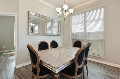 Dining room with crown molding, a chandelier, and