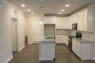 Kitchen with a sink, light stone counters, dark wo