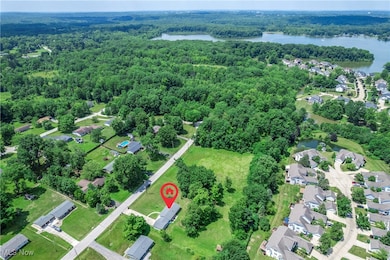 Aerial view of property and surrounding area featuring nearby suburban area