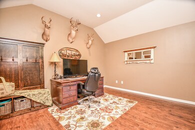 Another view of the study with a dramatic vaulted ceiling and laminate floors.
