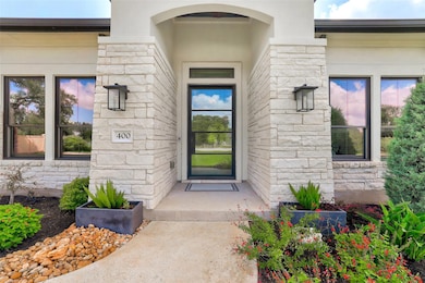 Entrance to property with stone siding and stucco