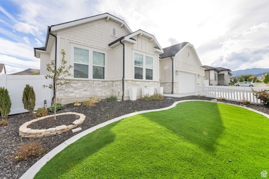 View of front of property featuring board and batten siding, stone siding, and an attached garage