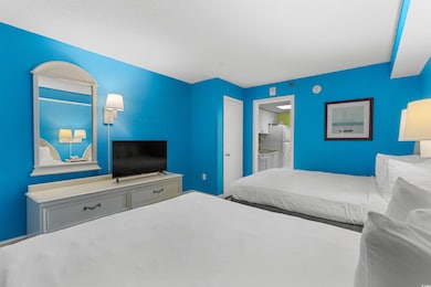 Bedroom featuring freestanding refrigerator and ensuite bathroom