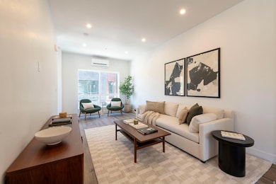 Living room featuring recessed lighting, light wood-type flooring, and a wall mounted AC