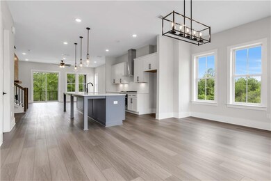 Kitchen with white cabinetry, an island with sink,