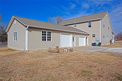 One garage door leads to a single garage with attached partially finished studio, office, or craft room and access to the kitchen. The back garage door leads to a HUGE 1500 square foot heated and cooled workshop with it's own HVAC unit.