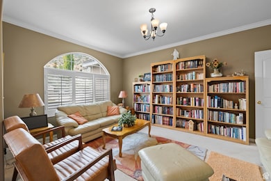 Living room featuring a chandelier and crown molding