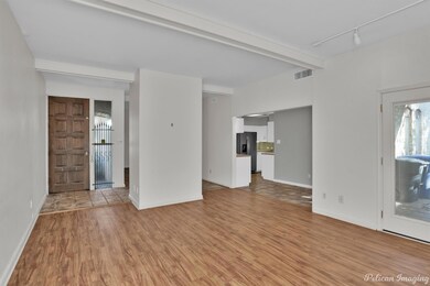 Unfurnished living room featuring beam ceiling, li