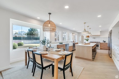 Dining room with baseboards, light wood finished floors, and recessed lighting