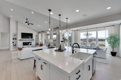 Kitchen with white cabinetry, light wood-style floors, recessed lighting, a kitchen island with sink, and hanging light fixtures