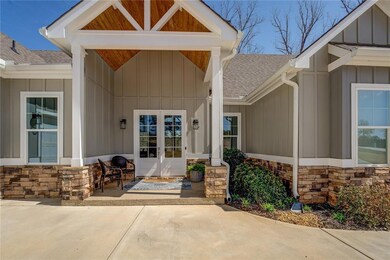 Doorway to property with a shingled roof, board and batten siding, and stone siding