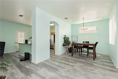Dining area with arched walkways and wood finished floors