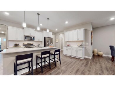 1.jpOne level living! This dream kitchen features plenty of cabinet space, an oversized center island, quartz countertops, tile backsplash, walk-in pantry and the popular slate finish appliances! Photo of model home, colors and finishes will vary.