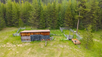 Aerial view of property and surrounding area featuring a forest