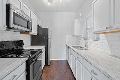 Kitchen with a sink, a textured ceiling, light st