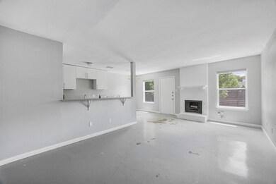 Unfurnished living room with unfinished concrete 