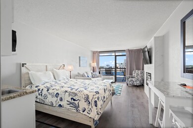 Bedroom featuring a wall of windows, dark hardwood / wood-style flooring, access to exterior, and a textured ceiling
