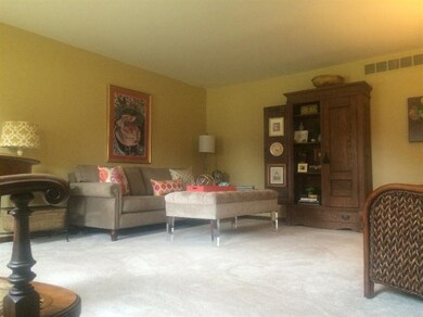 Formal living room with neutral carpet & large windows for lots of natural light