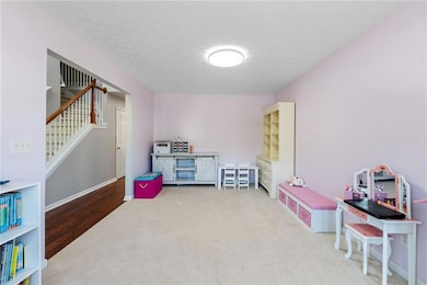 Game room with carpet, a textured ceiling, and bas