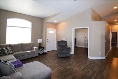 Living area with dark wood-style flooring, baseboa