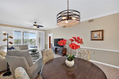 Dining room with ornamental molding, light tile patterned floors, a chandelier, and ceiling fan