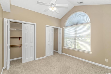 Unfurnished bedroom with carpet floors, lofted ceiling, two closets, and baseboards