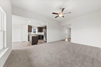 Unfurnished living room featuring ceiling fan and 