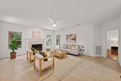 Living room with ceiling fan, light tile patterne