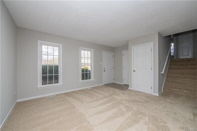 tiled entryway with carpeted living room floors an