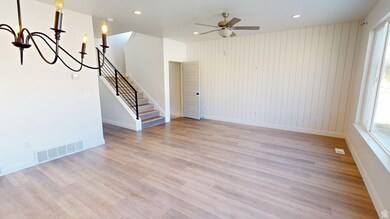 Unfurnished living room featuring light wood-style floors, stairs, recessed lighting, a chandelier, and ceiling fan
