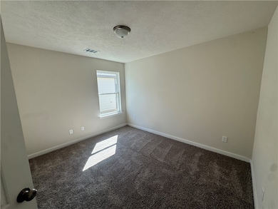 Unfurnished room featuring carpet floors and a textured ceiling