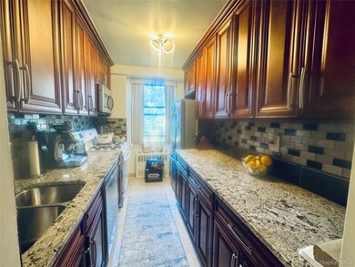 Kitchen with light stone counters, tasteful backsplash, stainless steel appliances, and light tile patterned floors