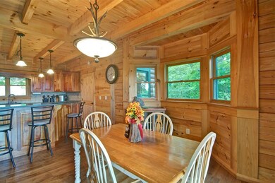Dining area featuring a wood ceiling with exposed beams, light wood-type flooring, and wood walls
