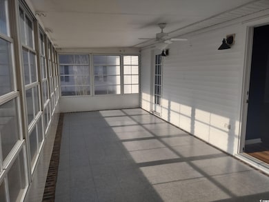 sunroom with a ceiling fan and light