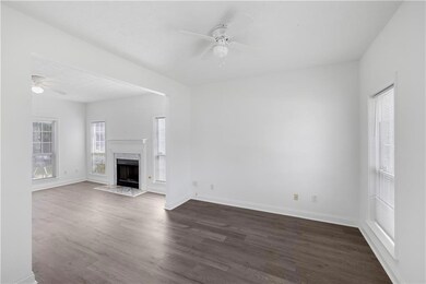 Unfurnished living room featuring a ceiling fan, dark wood-type flooring, and a premium fireplace