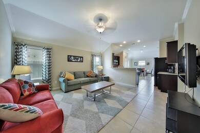 Large living room, tile flooring throughout, elevated ceilings with upgraded ceiling fans and recessed lighting.