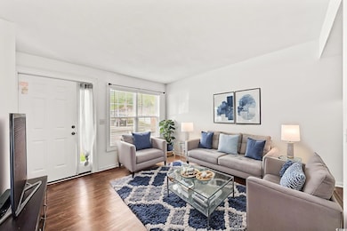 Living area with dark wood-style floors virtually staged