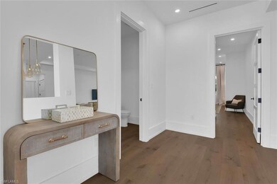 Corridor with wood finished floors, baseboards, an