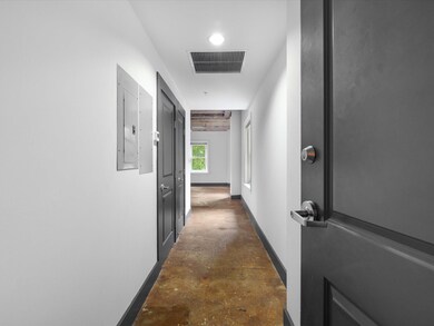 Hallway with concrete floors, visible vents, elect