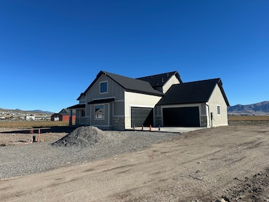 View of front of house featuring a mountain view, driveway, stone siding, and a garage