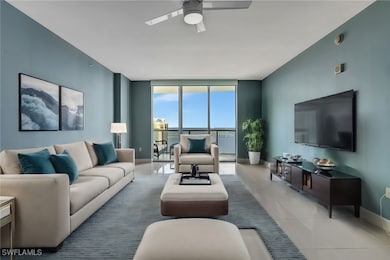Living room featuring ceiling fan, expansive windo